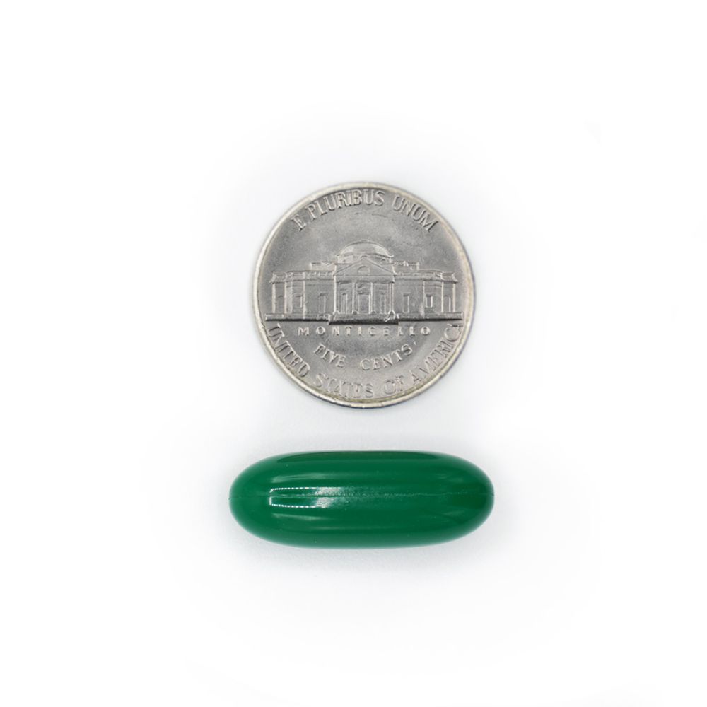 Gotu Kola capsule next to a coin for size comparison